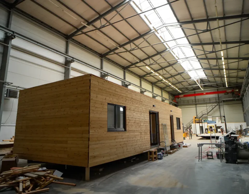 Dřevěný mobilní dům ABODES ve výrobní hale.